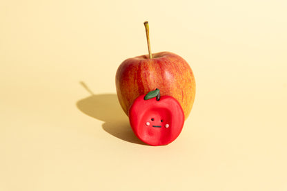 Detailaufnahme eines Apfel-Sorgensteins mit Wurmfigur für sensorisches Spielen und taktile Stimulation.